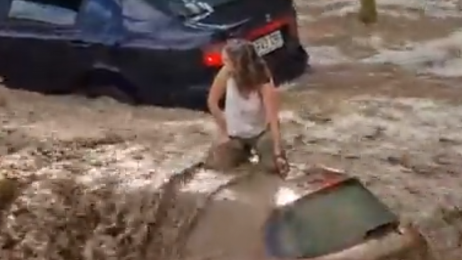 BUJICA NOSI ŽENU ZAROBLJENU NA KROVU VOZILA Jedva se drži (VIDEO)