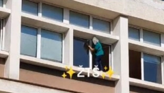 RIZIKUJE ŽIVOT ZBOG PROZORA Spremačica visi na simsu škole, usijale se mreže (VIDEO)
